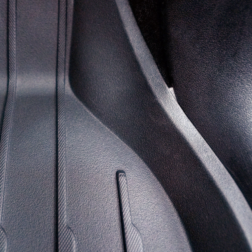 The front floor mats have tabs that hook under the trim to keep in place better. | All-Weather Floor Mats for Model Y